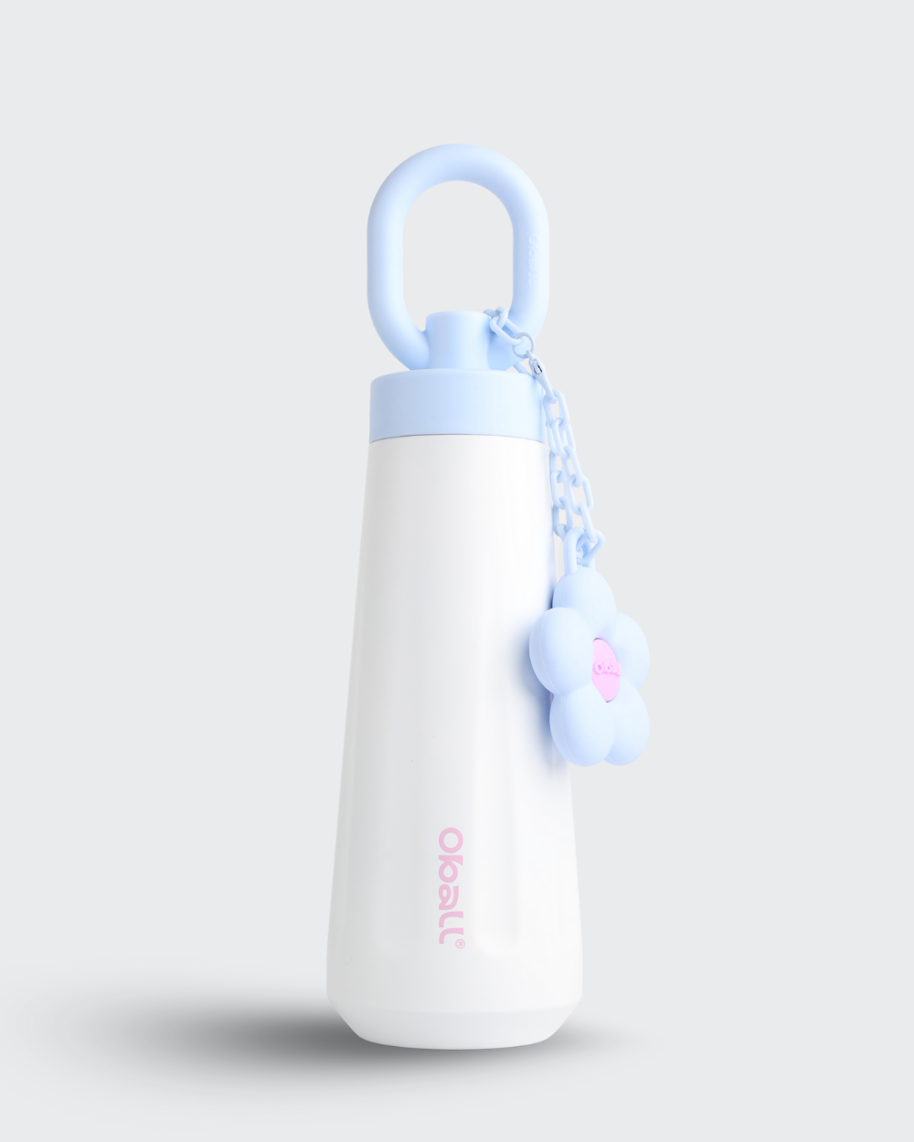 White bottle with blue cap and keychain on a light gray background